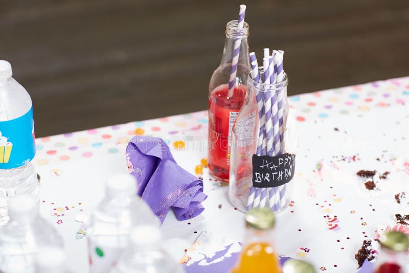 Flaskor på den smutsiga tabellen efter födelsedagparti royaltyfri bild Flaskor på den smutsiga tabellen efter födelsedagparti royaltyfri bild