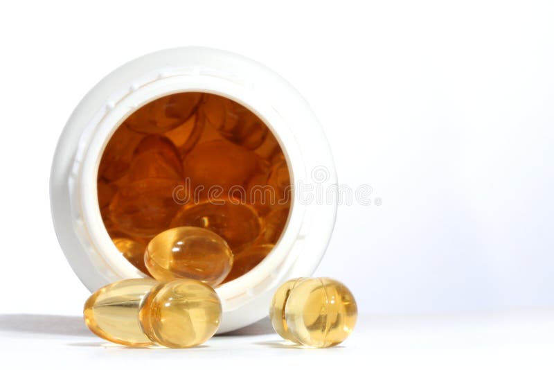 Yellow capsules and white pill box. Yellow capsules and white pill box