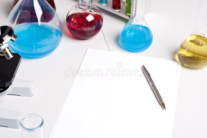 Flasks, pen, blank paper, workplace