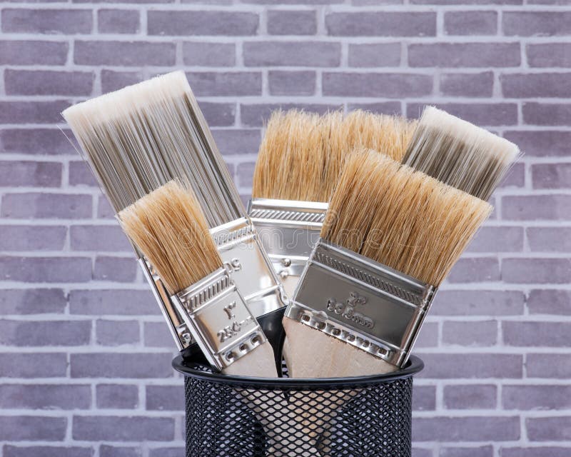 Flat Chip and Flat Cut Utility Paint Brushes on Brick Wall Stock Photo