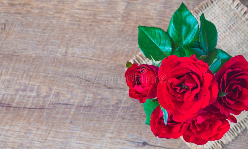 Flat lay of Beautiful rose red on sack and wooden table stock photos Flat lay of Beautiful rose red on sack and wooden table stock photos