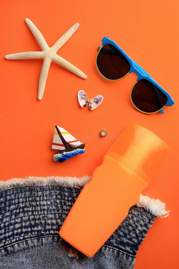 Flat lay composition with bottle of sunscreen on coral background royalty free stock photo