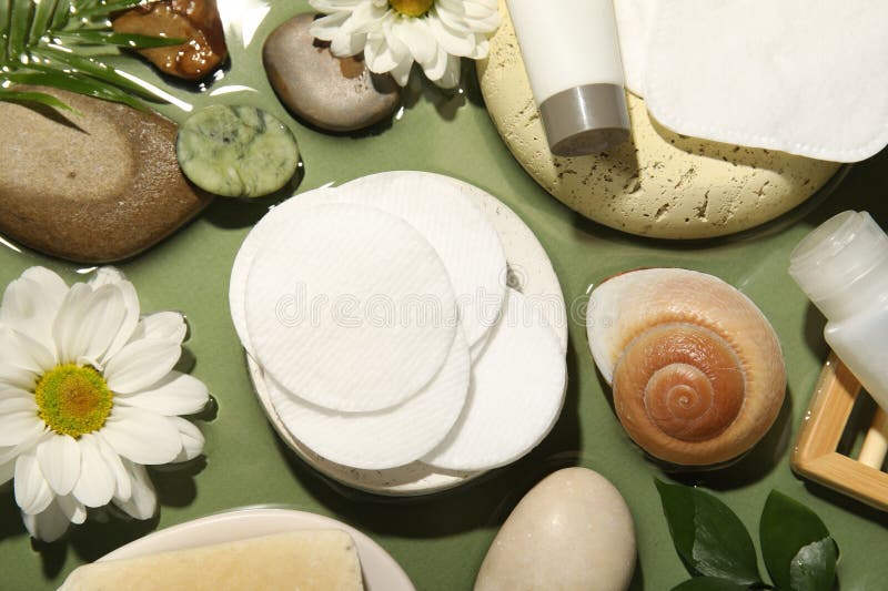 Flat lay composition with cotton pads and swabs on green table stock photo