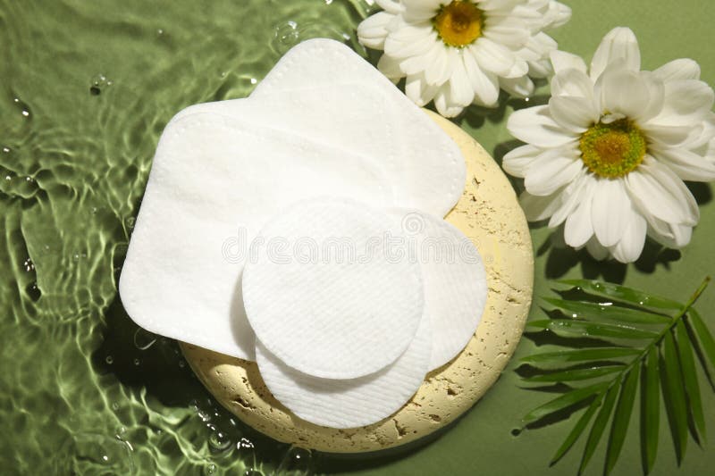 Flat lay composition with cotton pads on wet green surface royalty free stock image