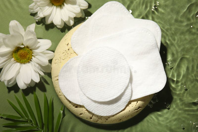 Flat lay composition with cotton pads on wet green surface stock image