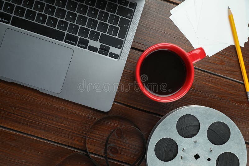Flat lay composition with film reel and laptop on wooden table stock images