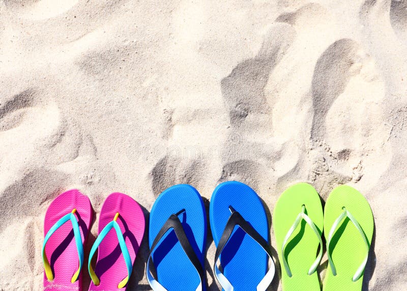 Flat lay composition with flip flops on sand in summer. Beach accessories