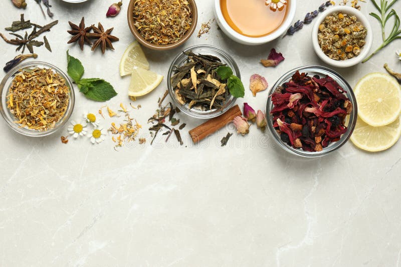 Flat lay composition with fresh brewed tea and dry leaves on light table, space for text