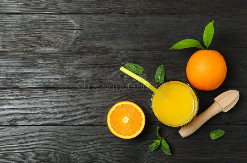 Flat lay composition with fresh orange juice, wooden juicer, mint and oranges on wooden background, top view stock photo Flat lay composition with fresh orange juice, wooden juicer, mint and oranges on wooden background, top view stock photo