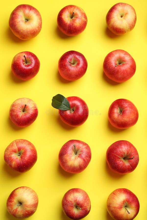 Flat lay composition with many red apples on yellow background royalty free stock image