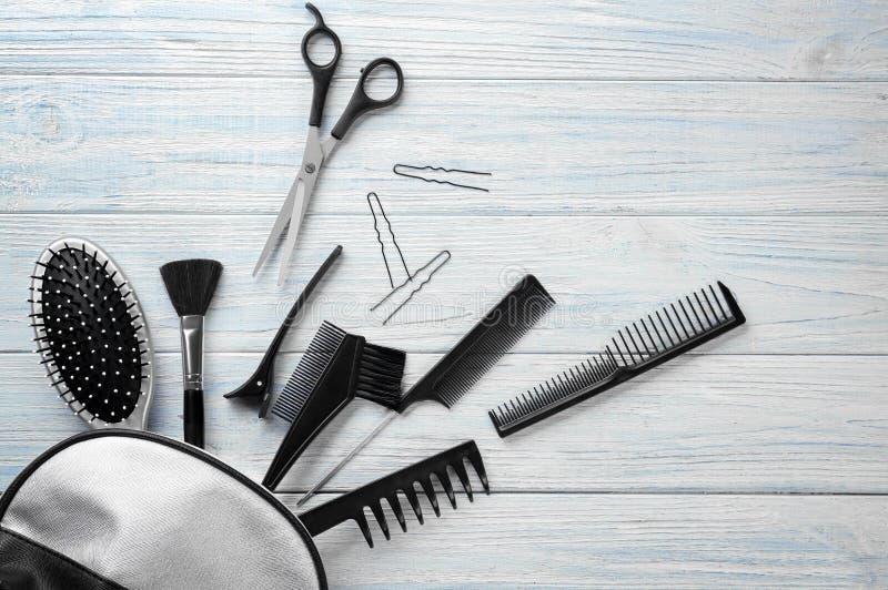 Flat lay composition with professional hairdresser\'s tools on wooden background