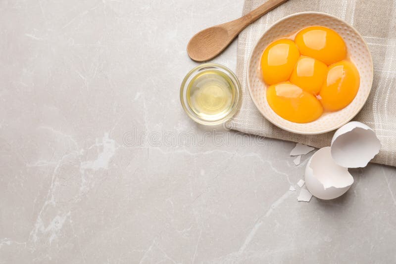 Flat Lay Composition with Raw Egg Yolks and Whites on Light Grey Marble Table, Space for Text