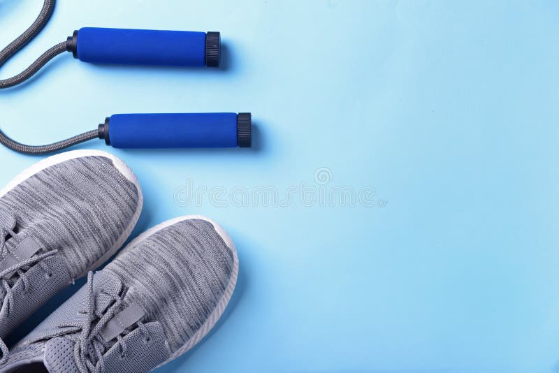 Flat Lay Composition with Sneakers and Jumping Rope on Color Background