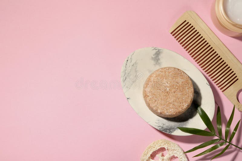 Flat Lay Composition of Solid Shampoo Bar, Leaf and Comb on Pink