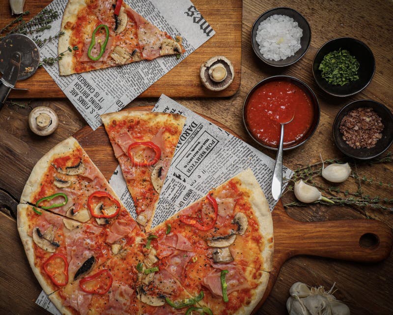 Flat Lay of a Delicious Italian Pizza, Sauce, Spices on a Table Stock