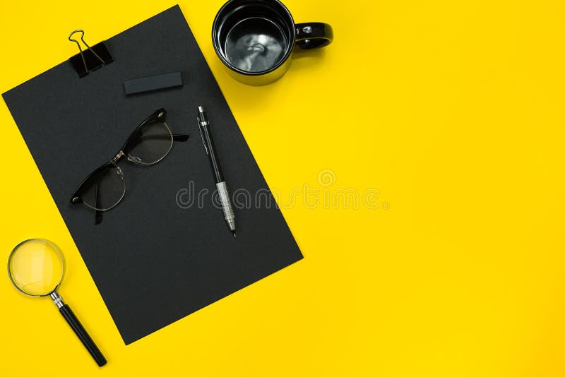 Flat lay display of business office gadgets with notepad, cup, pen, develop, glasses and etc. Top view. Black office