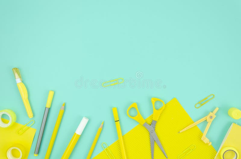 Flat lay frame yellow stationary school supplies on blue background. Copy space for text. Back to school concept