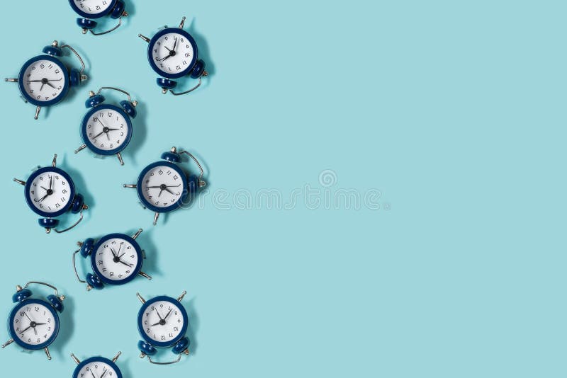 Flat lay retro beautiful new alarm clock on blue color background. Pattern. stock photos