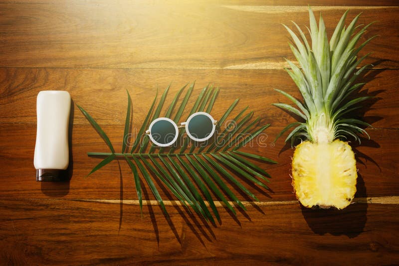 Flat lay of Sunscreen, sunglasses and pineapple fruit stock photography