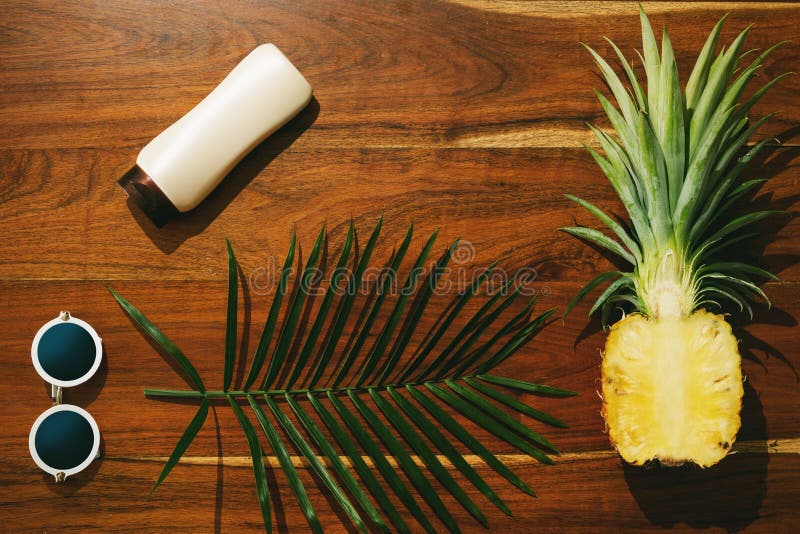 Flat lay of Sunscreen, sunglasses and pineapple fruit stock photography