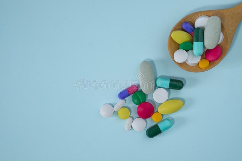 Płaski widok na wierzch kolorowych tabletek farmaceutycznych. wiele tabletek i tabletek w drewnianej łyżeczce obrazy royalty free