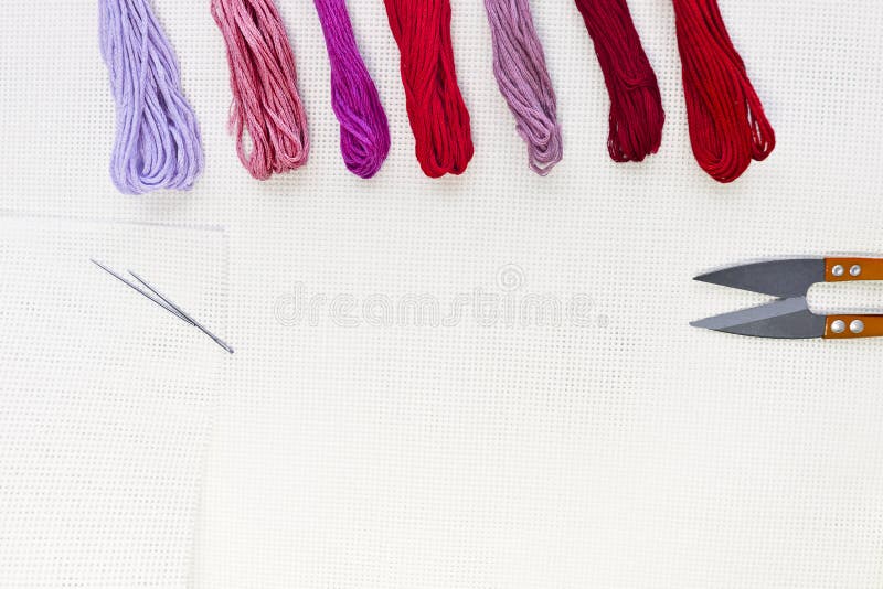 Flat Lay Top View with an Embroidery Canvas, Needles, Threads in Red