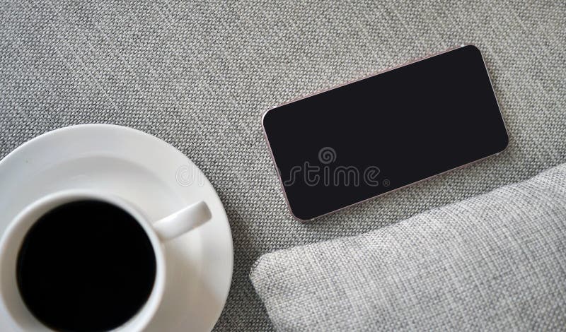 Flat Lay, Top view smartphone mockup and a cup of black coffee on fabric textile with copy space, digital NOMAD, freelancer royalty free stock image