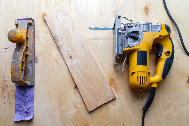 Flat Lay of a Yellow Electric Jigsaw and Hand Plane Ready for Work Use