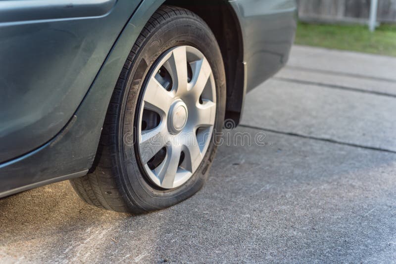 Flat Rear Tire on Green Car on Driveway of Parking Garage Close-up Stock Photo - Image of hole ...