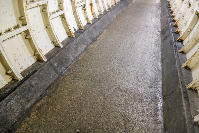 Flat stone floor and heavy iron plating on Thames under water tunnel wall. stock photos Flat stone floor and heavy iron plating on Thames under water tunnel wall. stock photos