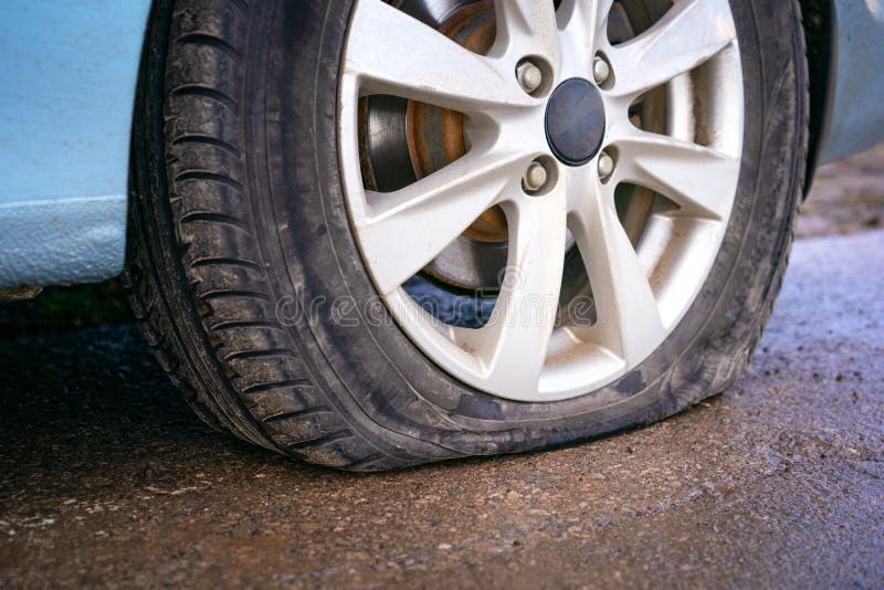 Flat tire of blue car on the road waiting for repair. Car tire leak because of nail pounding royalty free stock images Flat tire of blue car on the road waiting for repair. Car tire leak because of nail pounding royalty free stock images