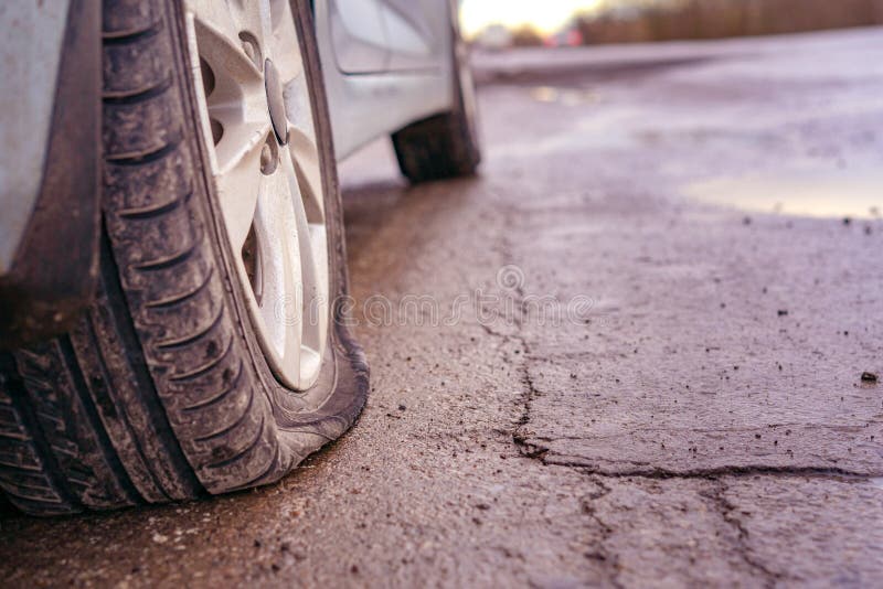 Flat tyre on road. Car tire leak because of nail pounding. Toned royalty free stock photo Flat tyre on road. Car tire leak because of nail pounding. Toned royalty free stock photo