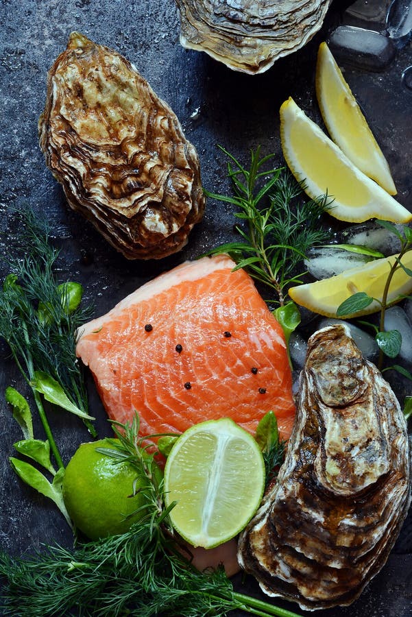 flatlay Composizione di frutti di mare freschi su un fondo scuro Trota ed ostriche con le erbe ed il limone immagini stock flatlay Composizione di frutti di mare freschi su un fondo scuro Trota ed ostriche con le erbe ed il limone immagini stock