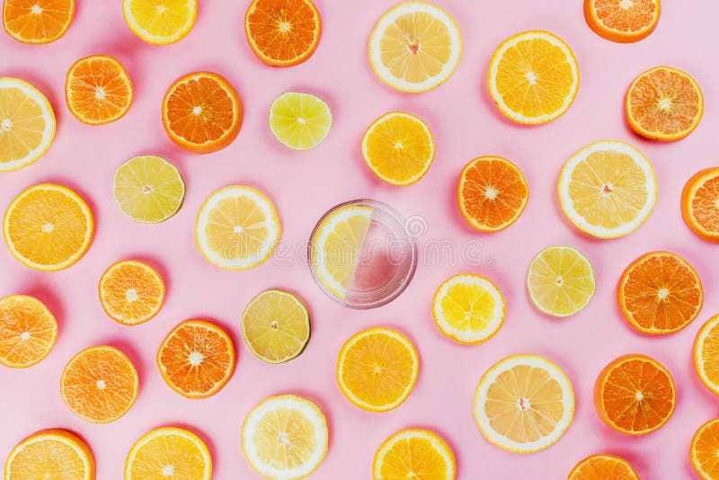 Flatlay of lemon water on pink background with various sliced citrus fruits stock photography Flatlay of lemon water on pink background with various sliced citrus fruits stock photography