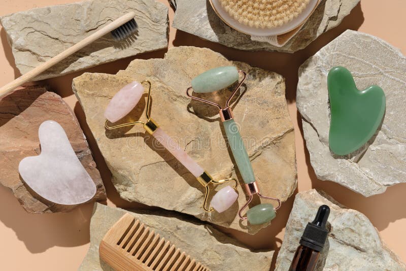 Flatlay with modern skin care tools jade and rose quartz roller massagers and guache scraper stock photography