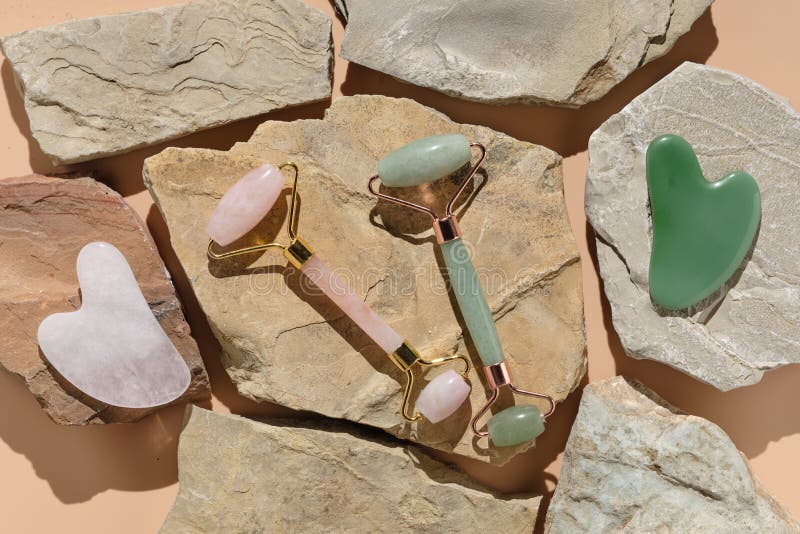 Flatlay with modern skin care tools jade and rose quartz roller massagers and guache scraper royalty free stock photo