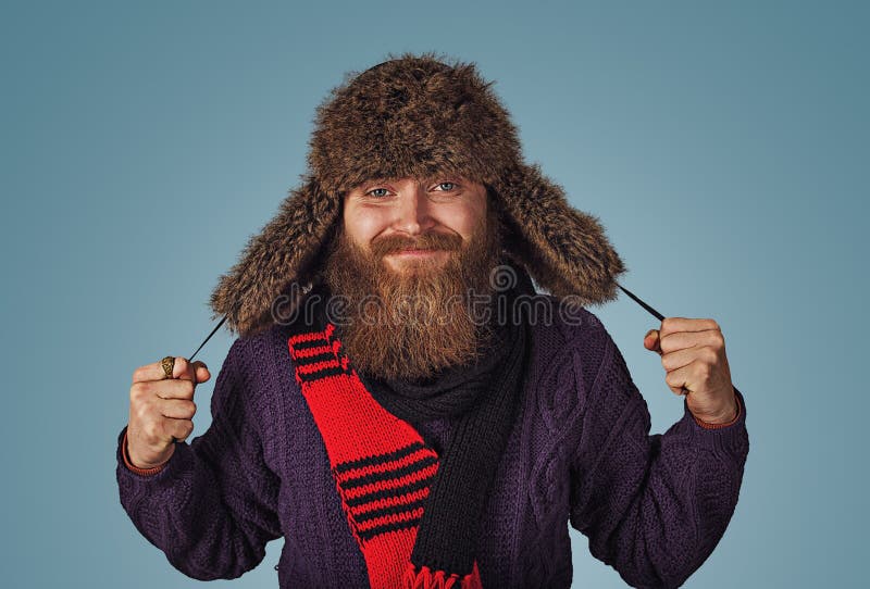 Flaumiger Pelzhut der Mannholdingvertretung in der purpurroten Strickjacke des roten Schals lizenzfreies stockfoto Flaumiger Pelzhut der Mannholdingvertretung in der purpurroten Strickjacke des roten Schals lizenzfreies stockfoto