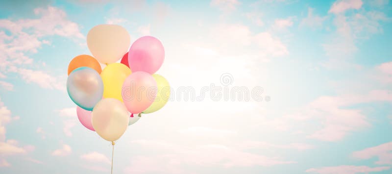 Flerfärgade ballonger för tappning med gjort med en retro instagramfiltereffekt på blå himmel royaltyfria foton