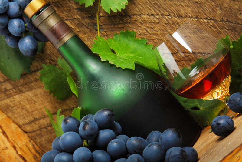 Fles, glas cognac en tros druiven royalty-vrije stock fotografie