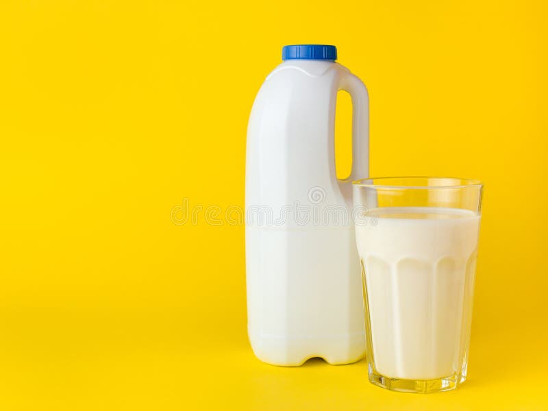 Fles met verse melk met handvat en glas melk op gele achtergrond Spot omhoog voor merkmalplaatje stock afbeeldingen Fles met verse melk met handvat en glas melk op gele achtergrond Spot omhoog voor merkmalplaatje stock afbeeldingen