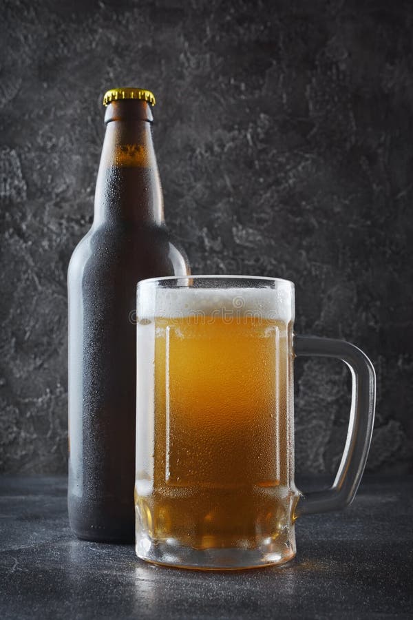 Fles van koude bier en glasmok met schuim royalty-vrije stock foto Fles van koude bier en glasmok met schuim royalty-vrije stock foto
