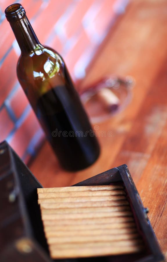 High angled view of bottle of wine and open box box of cigars. High angled view of bottle of wine and open box box of cigars.