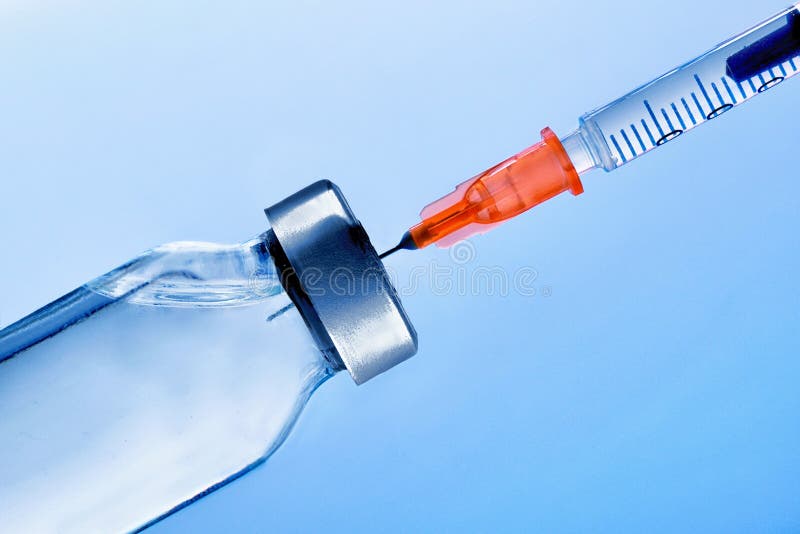 Flesje met vernietigde spuit dicht omhoog en blauwe achtergrond royalty-vrije stock afbeeldingen Flesje met vernietigde spuit dicht omhoog en blauwe achtergrond royalty-vrije stock afbeeldingen