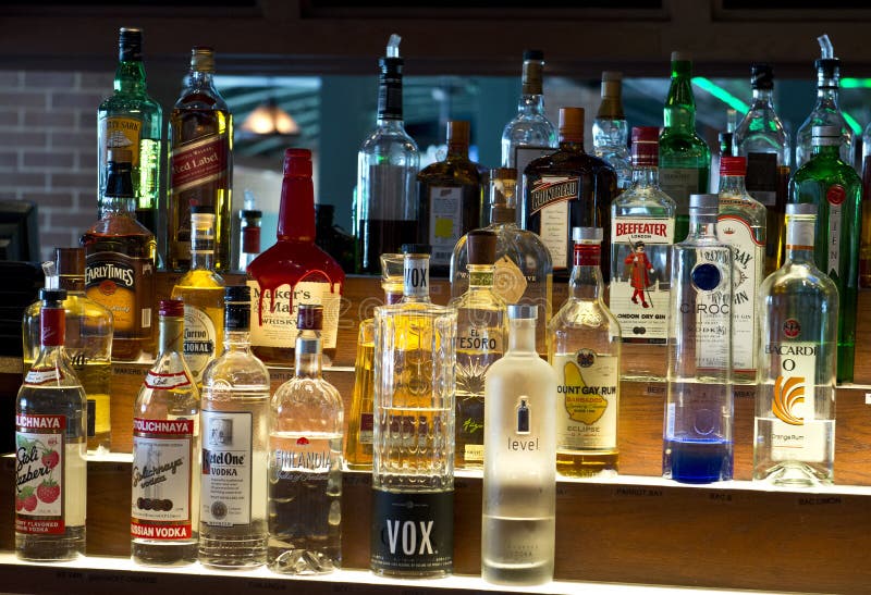 Different brands of booze, liquor, or alcohol in a bar or tavern. Multiple bottles of adult beverages can be seen. Different brands of booze, liquor, or alcohol in a bar or tavern. Multiple bottles of adult beverages can be seen.