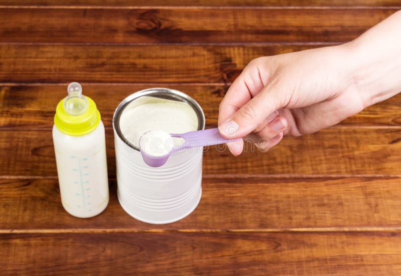 Flesvoeding van poedermelk van de moedermelkbank in donker hout stock fotografie