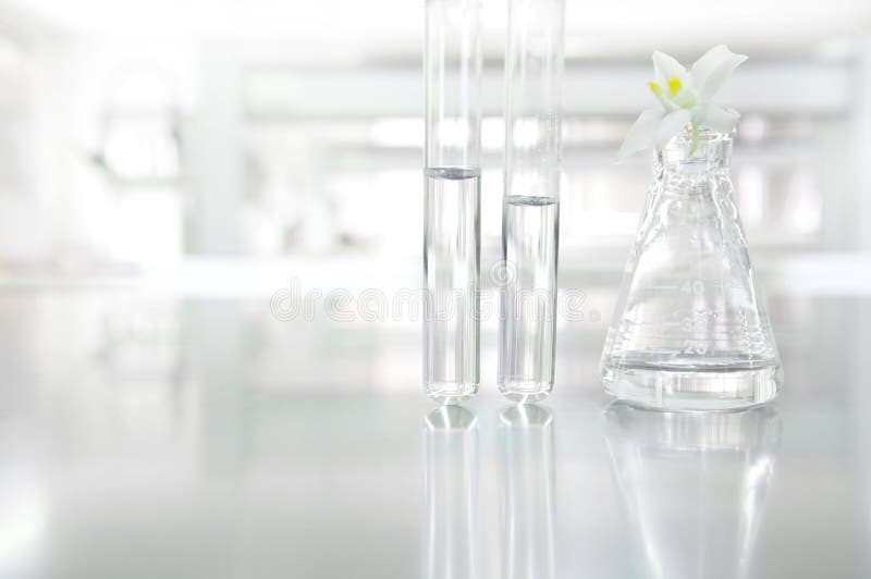Fleur blanche d'orchidée sur le tube en verre de flacon et à essai dans le cosm de la science