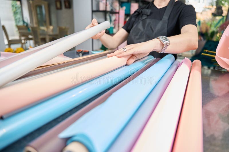 Fleuriste femme choisit le papier pour le bouquet dans la boutique fleurie. image stock