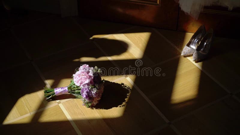 Fleurs de bouquet et chaussures de mariage et silhouette nuptiales de jeune mariée