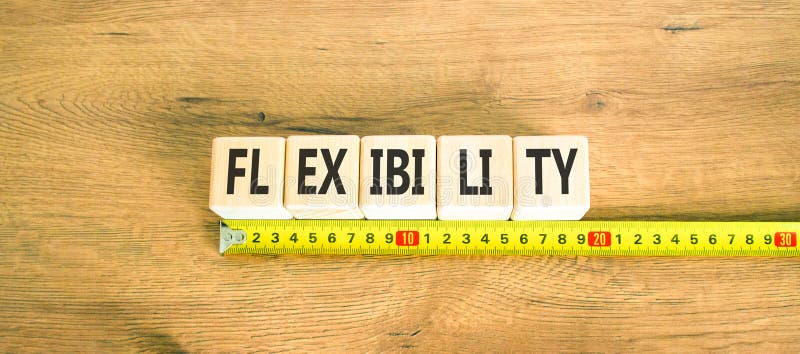 Flexibilitetssymbol. Begreppsflexibilitet för vackra träkuber. vacker bakgrund av trä. vacker gul linjal. royaltyfria bilder