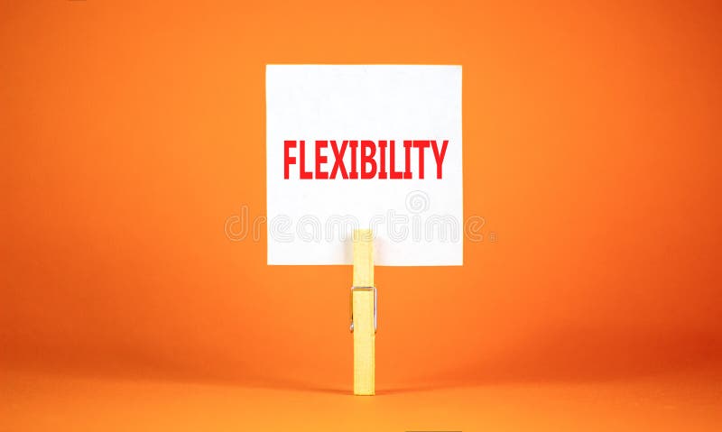 Flexibilitetssymbol. Konceptordflexibilitet för vackert vitpapper om kläder. vacker orange bakgrund. affärsverksamhet royaltyfria foton